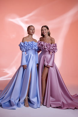 Off-the-shoulder blue and mauve evening dresses with ruffled necklines, fitted bodices, thigh slits, and full skirts