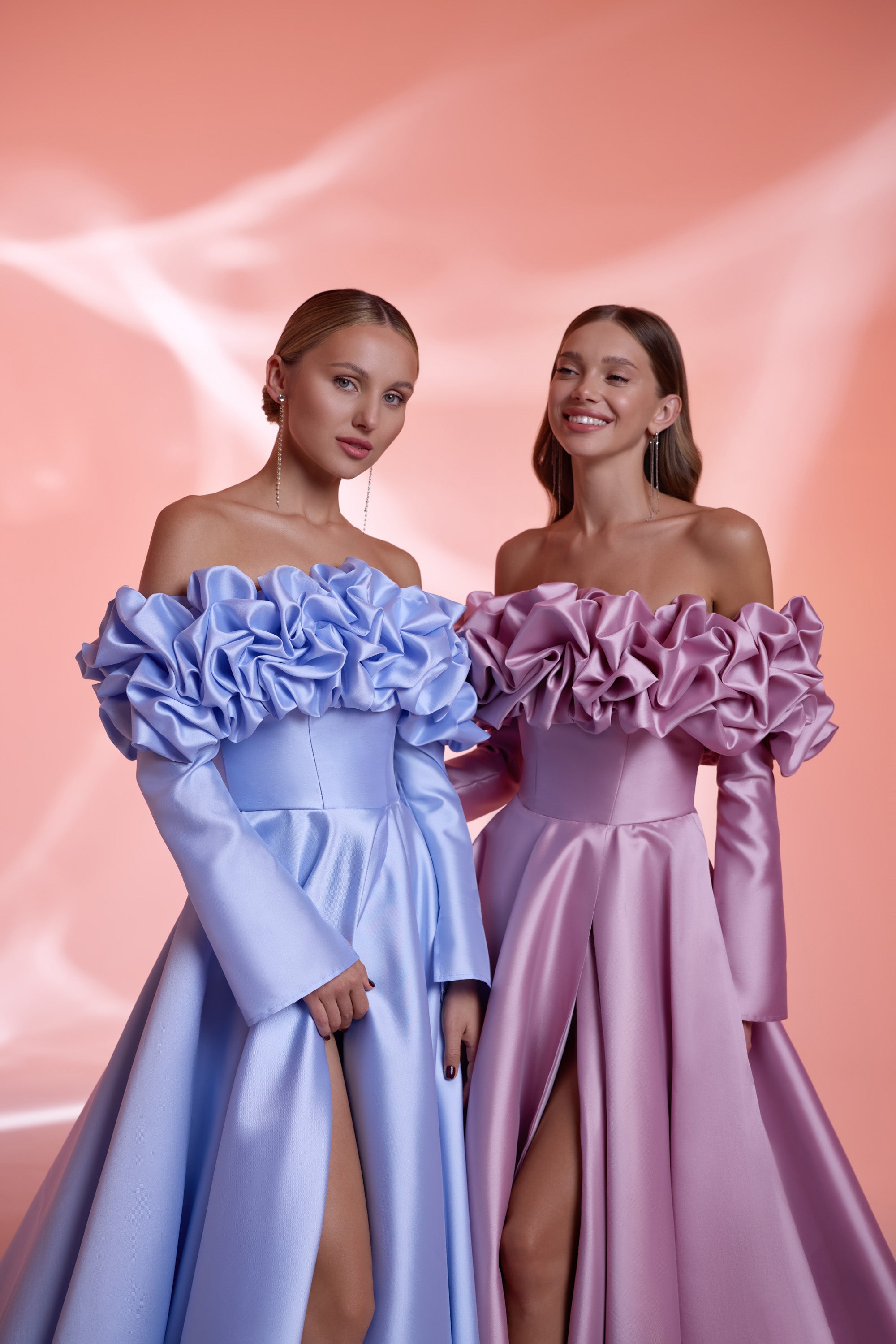 Close-up of blue and mauve evening dresses with sculptural ruffled off-the-shoulder necklines and satin bodices