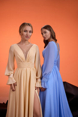 Champagne evening dress with a deep V-neck, sheer beaded panel, long sleeves, ruched waist, and thigh-high slit