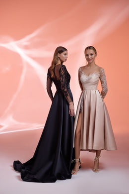 Black evening dress with sheer embellished sleeves, sparkling bodice, and a sweeping floor-length train