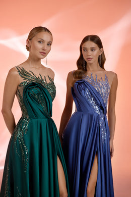 Close-up of emerald and blue evening dress bodices with crystal-studded detailing and draped satin fabric