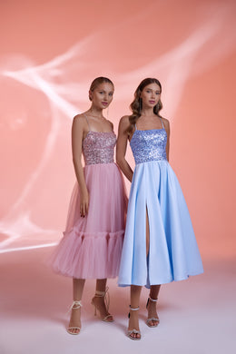 Pink and blue evening dresses with sparkling bodices, thin straps, flowing skirts, and a front slit