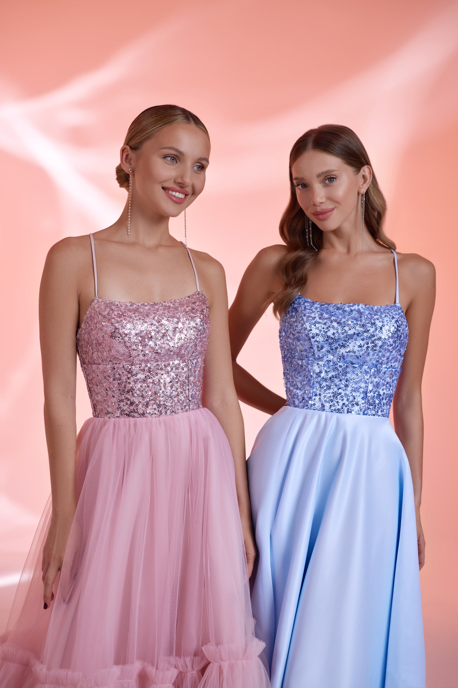 Close-up of pink and blue evening dresses featuring sequined square-neck bodices and delicate shoulder straps
