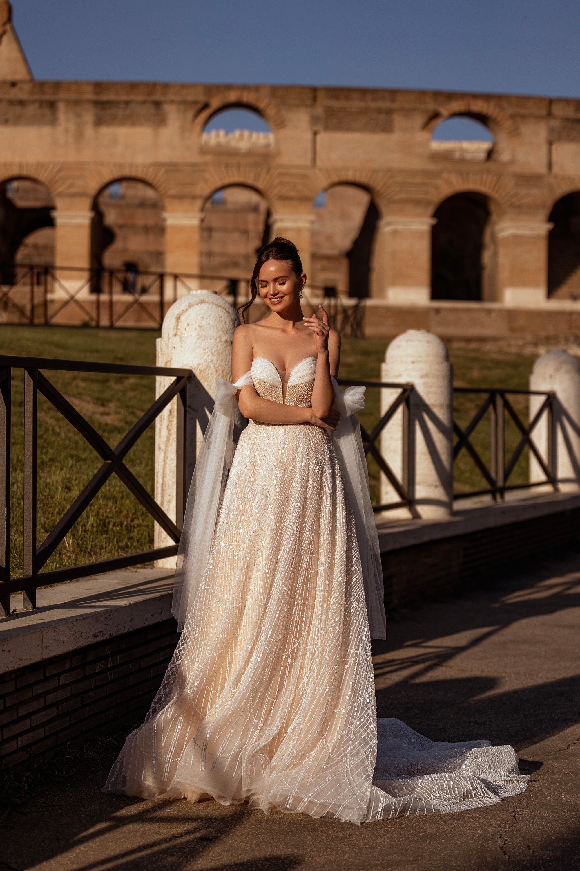 Sparkling ivory A-line wedding dress with a sweetheart neckline, sheer detachable sleeves, and trailing train