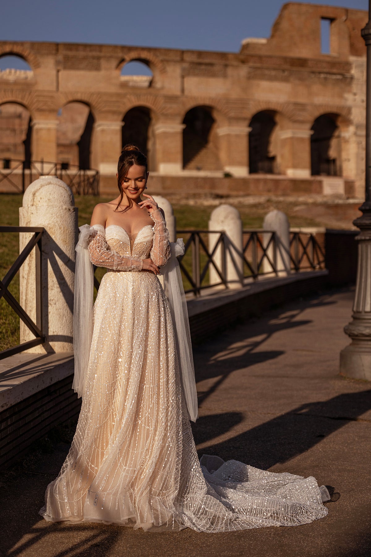 Ivory A-line wedding dress covered in shimmering beadwork with detachable sheer sleeves and a long train