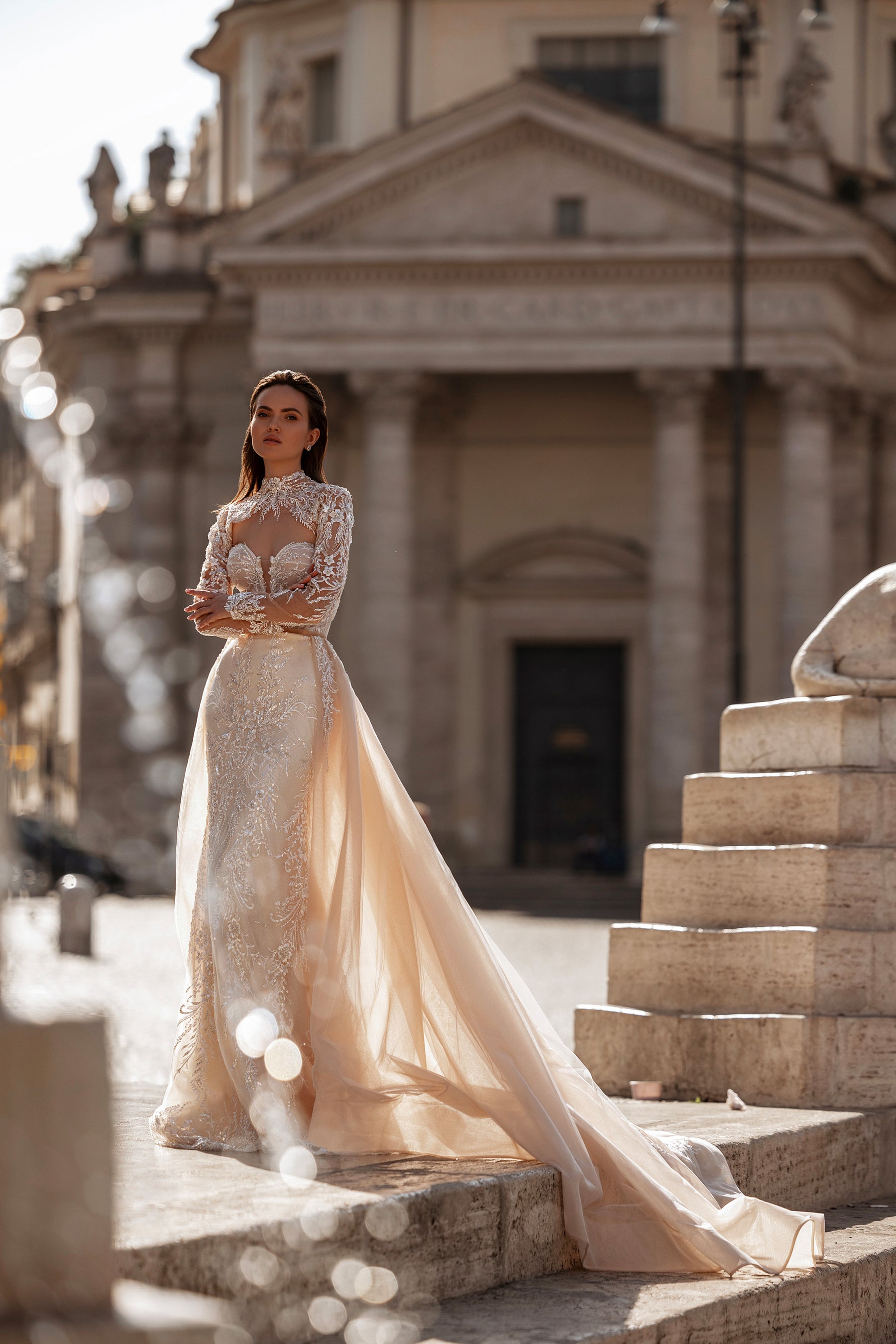 Ivory wedding dress with long sheer overskirt, sparkling lace embellishments, and an extended train
