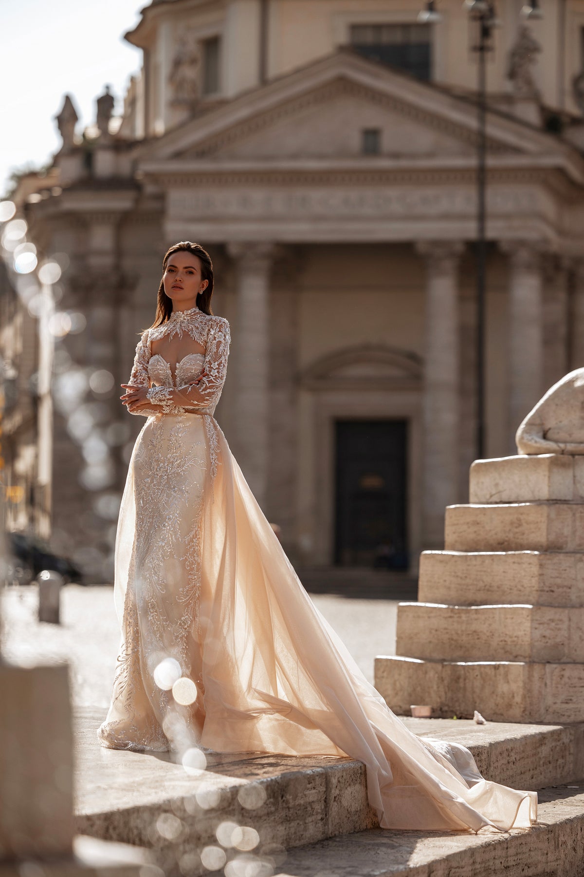 Ivory wedding dress with long sheer overskirt, sparkling lace embellishments, and an extended train