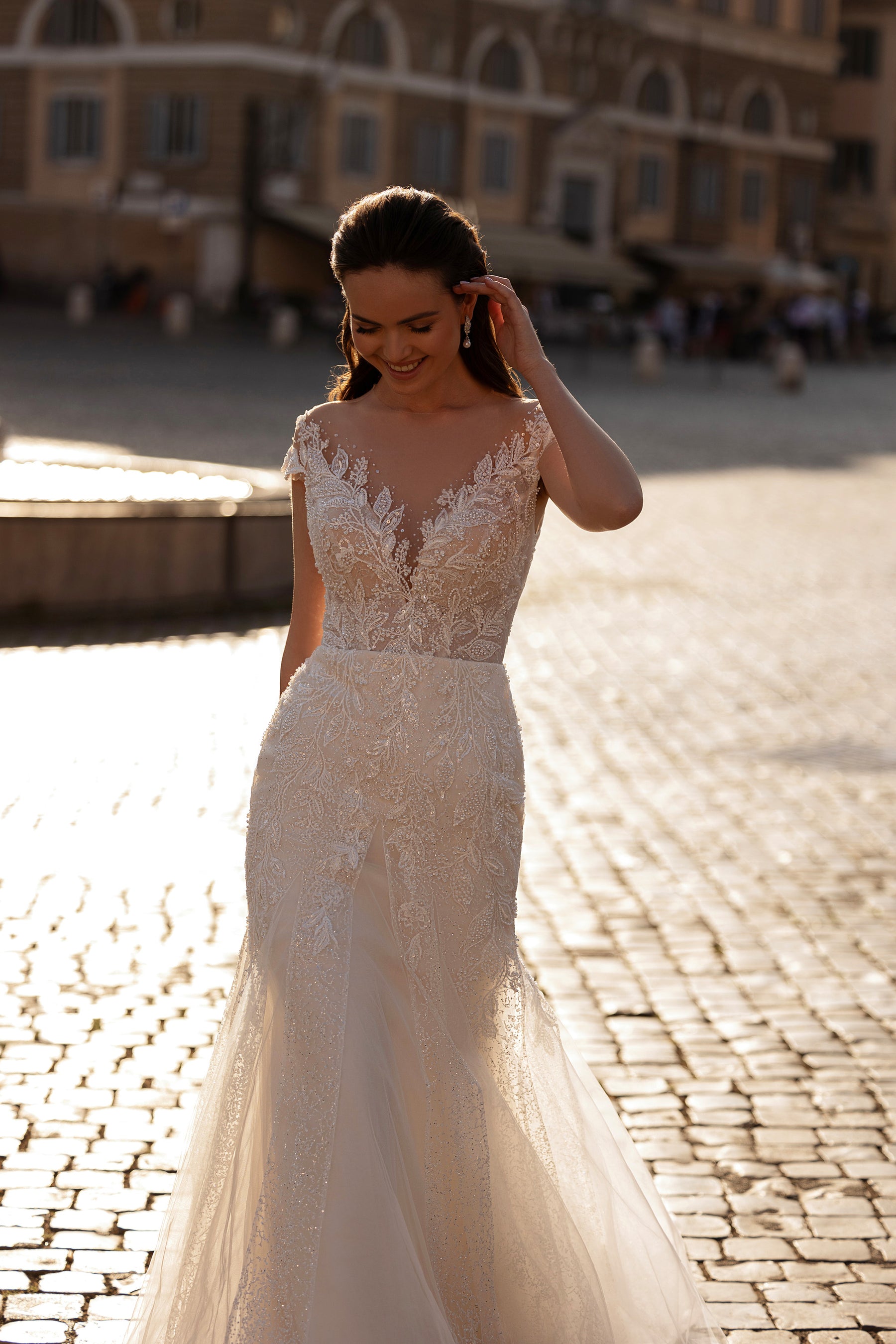Beaded ivory wedding dress with a sheer illusion neckline, short sleeves, fitted waist, and mermaid skirt