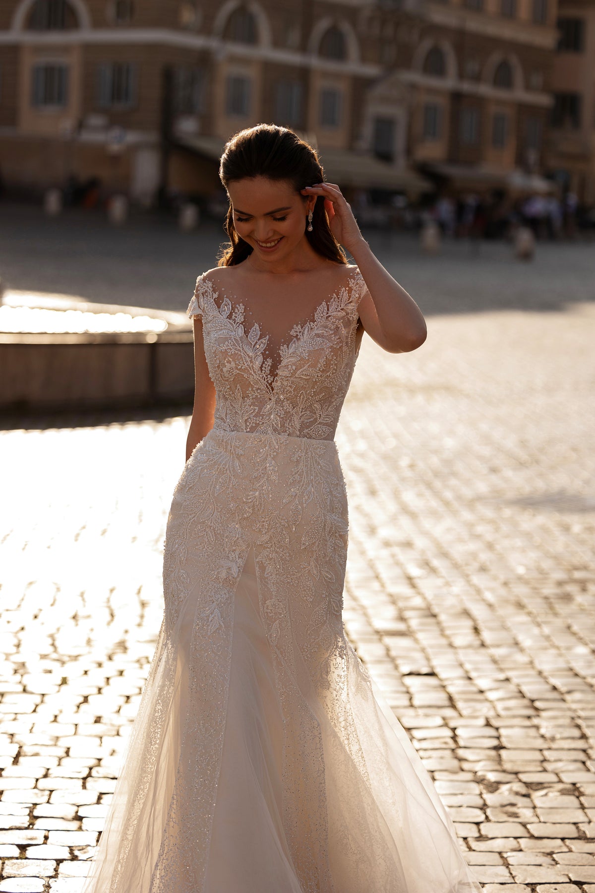 Beaded ivory wedding dress with a sheer illusion neckline, short sleeves, fitted waist, and mermaid skirt