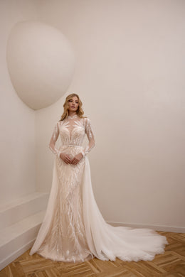 Ivory beaded lace sheath wedding dress with long sheer sleeves and a detachable overskirt train