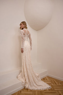 Beaded ivory wedding dress with a sheer V-back, long sleeves, and a dramatic floor-length train