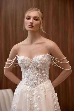 Strapless sweetheart blush wedding dress with a floral lace corset and pearl-draped shoulder accents