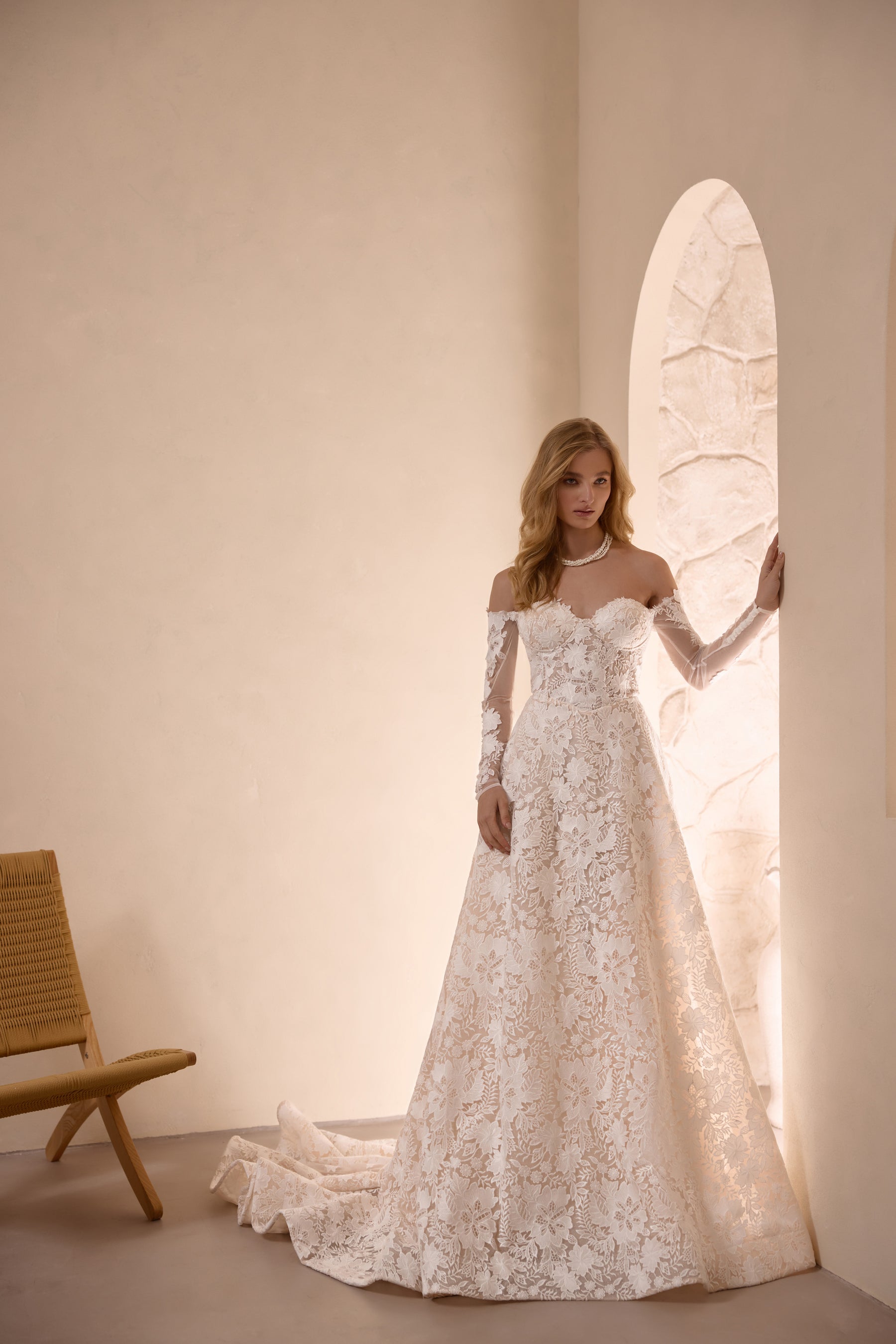 Ivory A-line wedding dress with floral lace, off-the-shoulder neckline, long sleeves, and a train