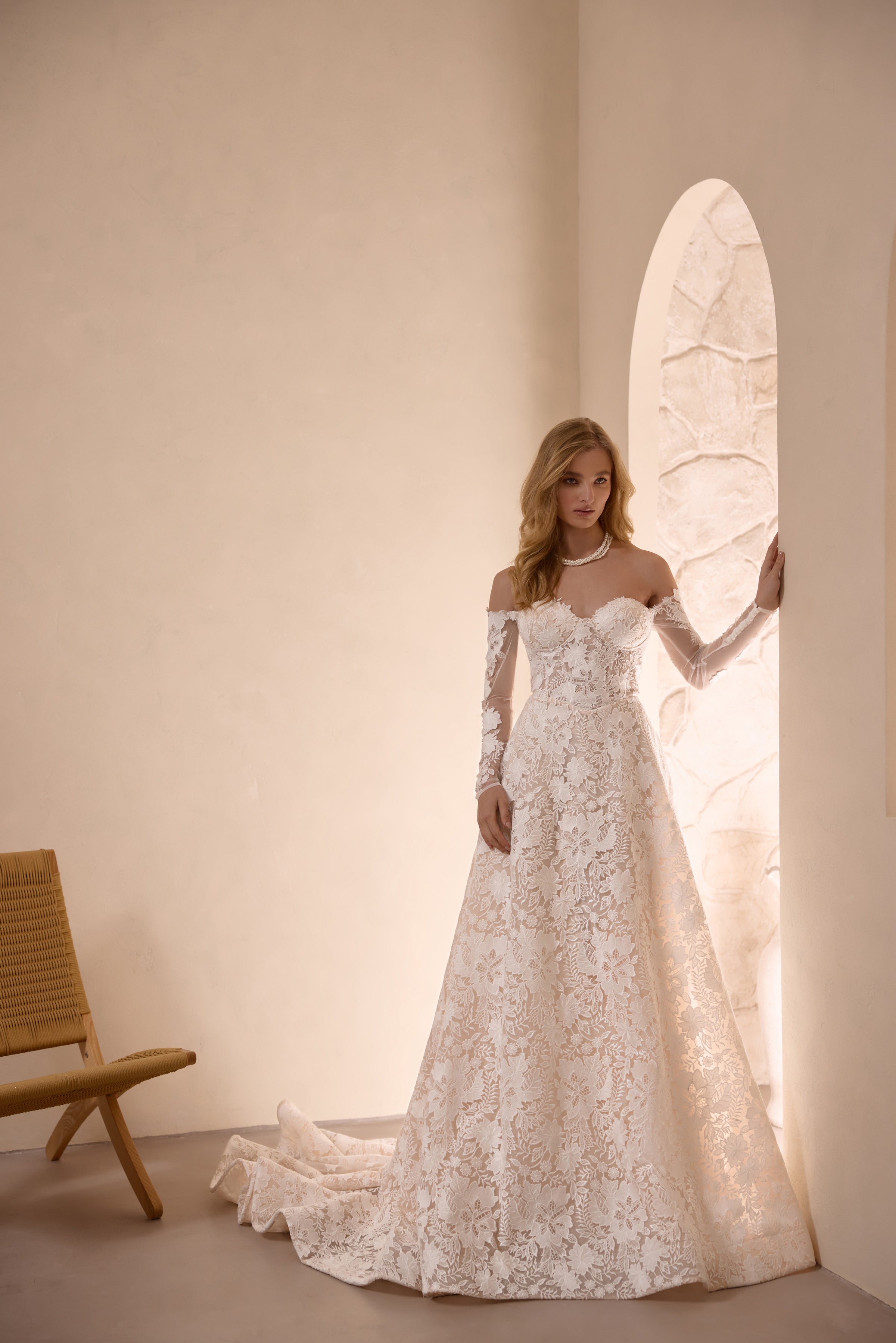 Ivory A-line wedding dress with floral lace, off-the-shoulder neckline, long sleeves, and a train