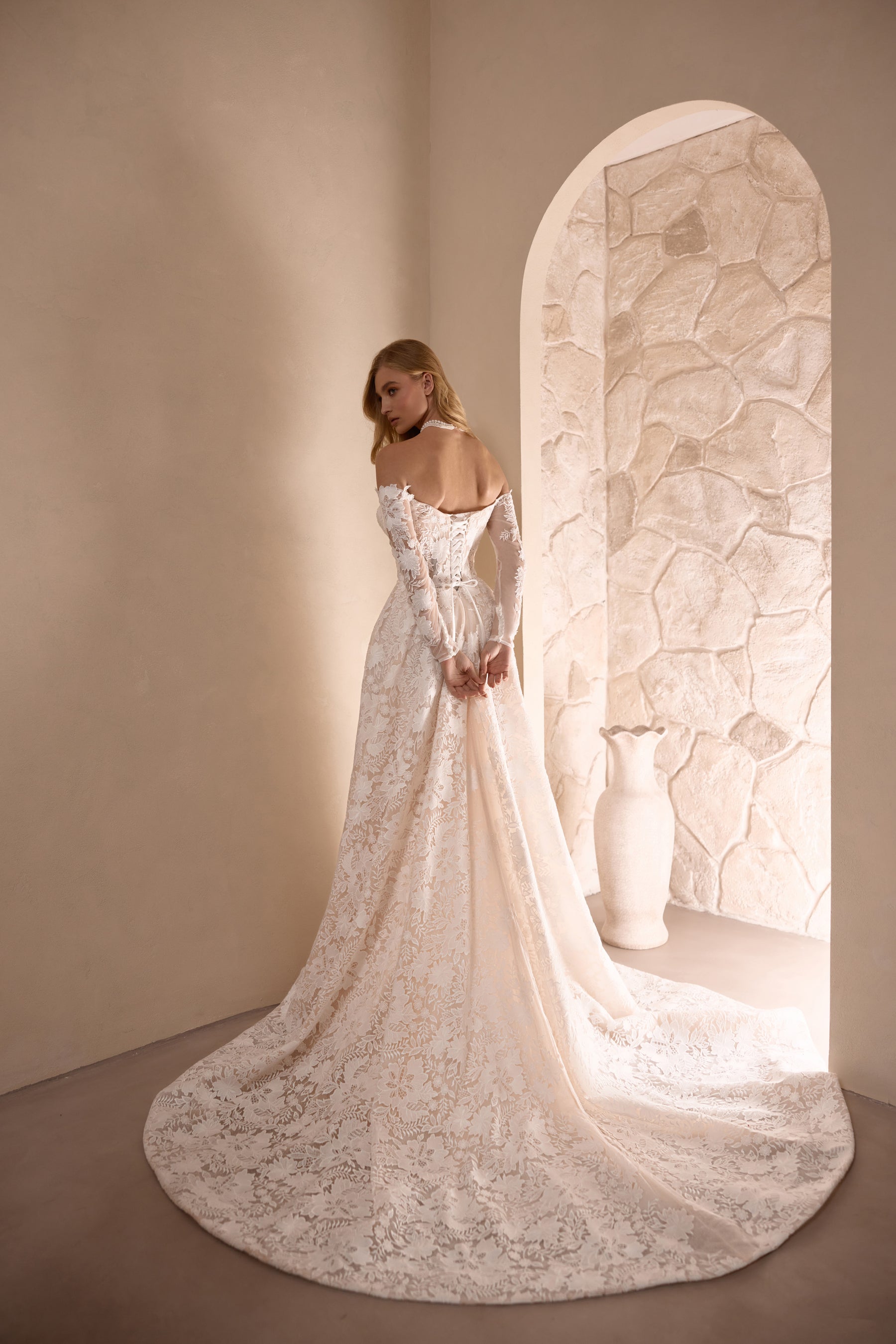 Ivory floral lace wedding dress with a fitted back and broad lace-trimmed train
