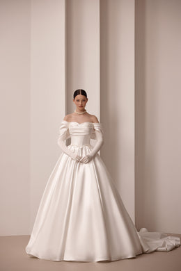 Ivory satin ball gown wedding dress with an off-the-shoulder neckline, fitted sleeves, and long train