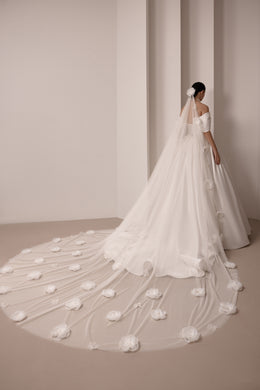 Ivory wedding dress shown with a long sheer veil covered in scattered floral appliqués