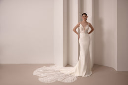 Fitted ivory wedding dress with floral lace bodice, thin straps, and a wide lace train