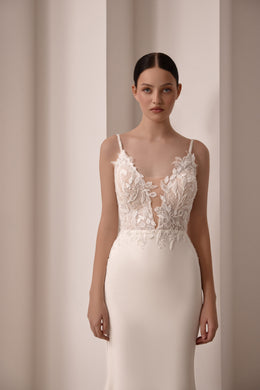 Ivory sheath wedding dress with thin straps, deep V-neckline, and floral lace bodice