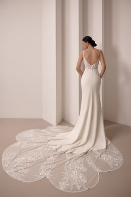 Low V-back ivory wedding dress with covered buttons and a detachable floral lace train