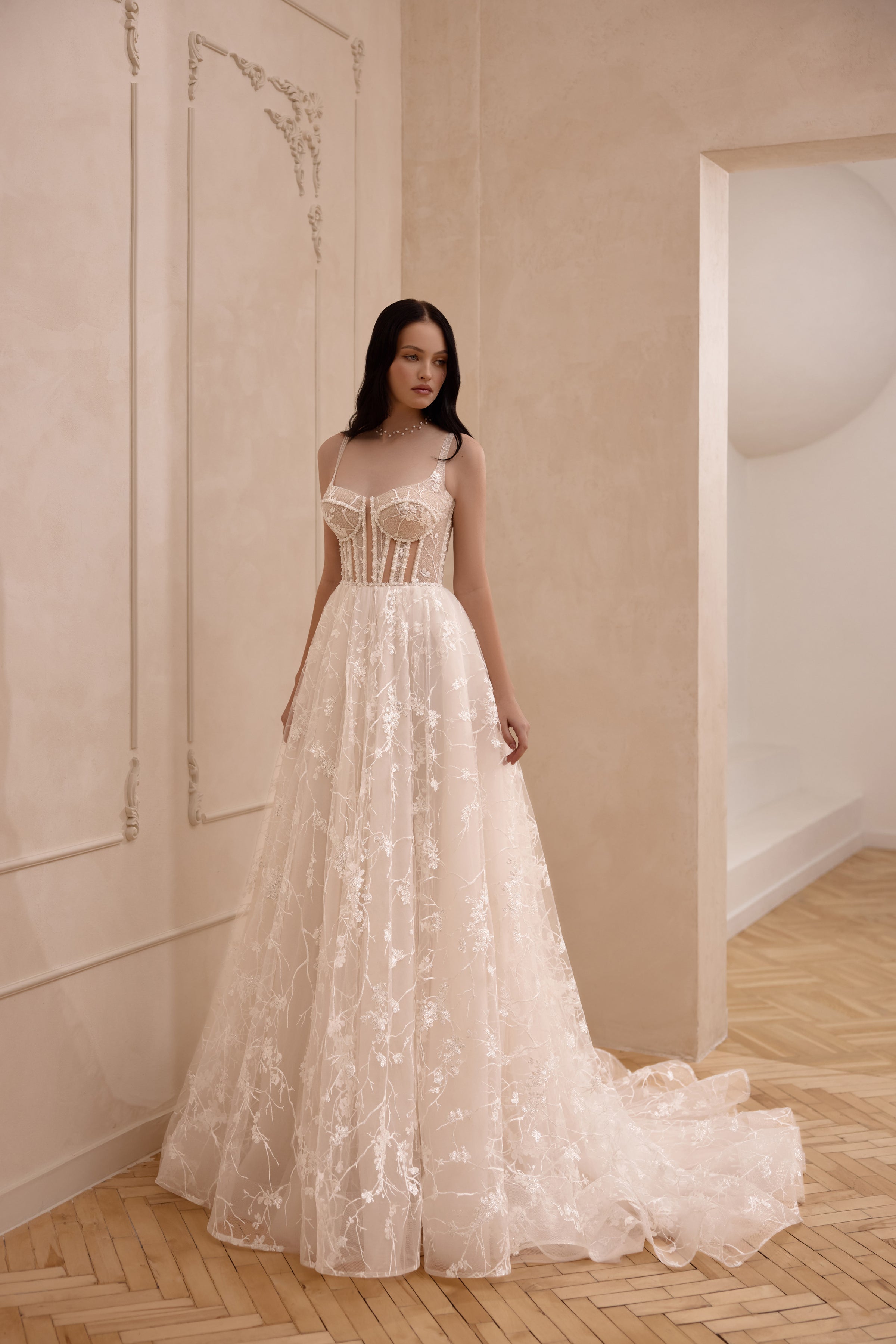Ivory A-line wedding dress with a square neckline, thin straps, corset bodice, floral lace, and chapel train