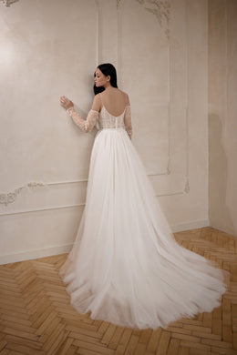 Open scoop back with sheer sleeves and a full tulle train on an ivory wedding dress