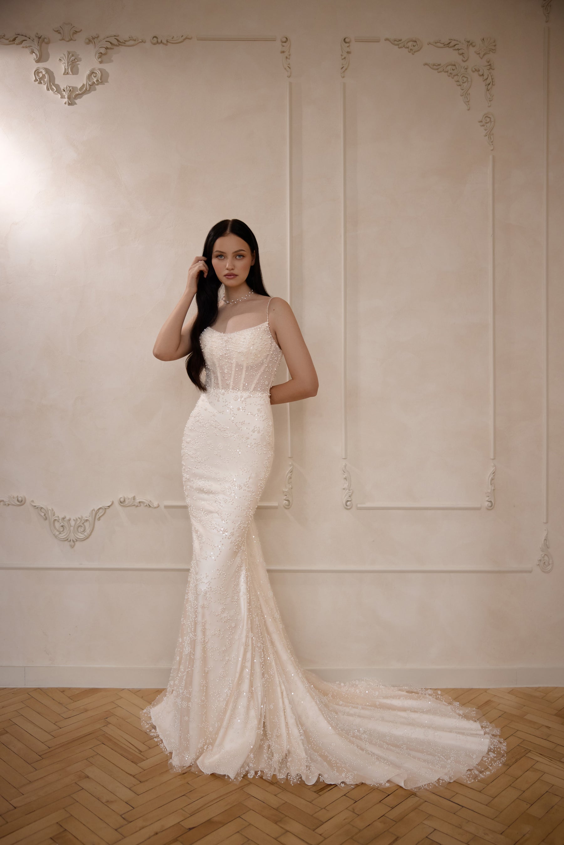 Ivory sleeveless sheath wedding dress with thin straps, shimmering beadwork, and a long train