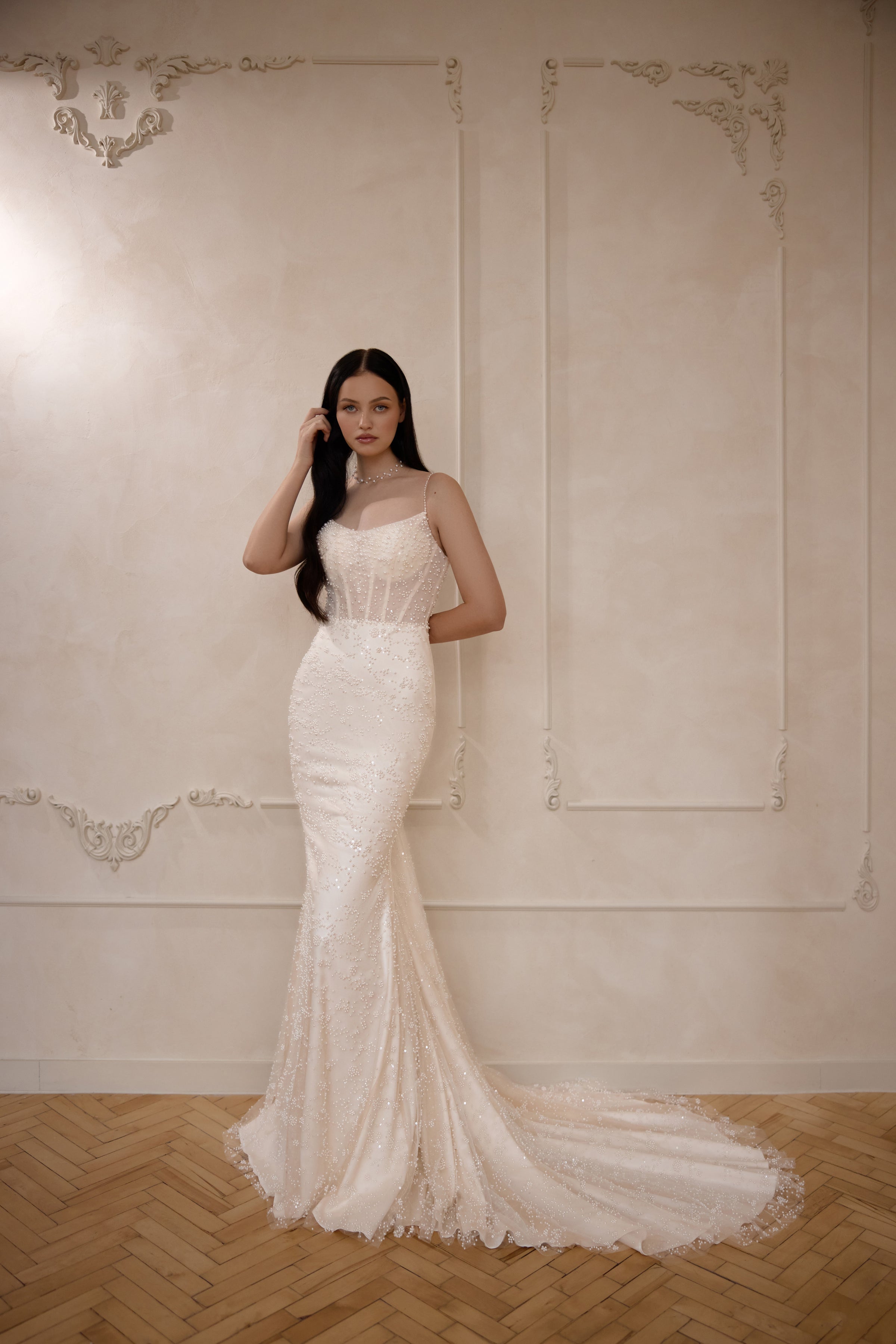 Ivory sleeveless sheath wedding dress with thin straps, shimmering beadwork, and a long train