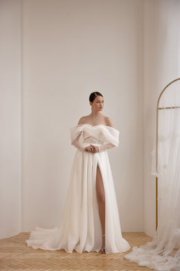 Ivory off-the-shoulder A-line wedding dress with a beaded bodice, high slit, and flowing train