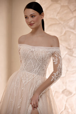 Close-up of an ivory wedding dress with a beaded off-the-shoulder bodice and floral lace sleeves
