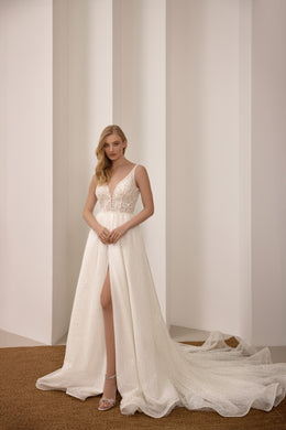 Sleeveless ivory wedding dress with a V-neck, sparkling A-line skirt, front slit, and train