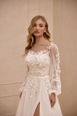 Close-up of an ivory wedding dress with a scoop neckline, sheer floral lace sleeves, and appliqué bodice