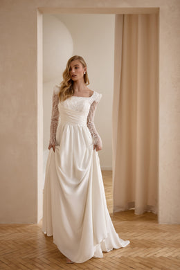 Ivory wedding dress with a square neckline, sheer lace sleeves, ruched waist, and draped satin skirt
