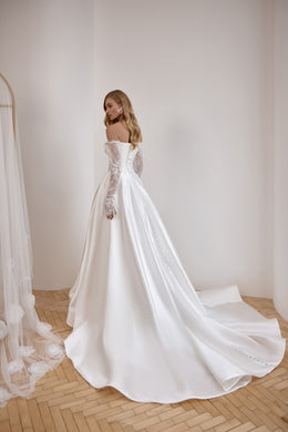 Ivory wedding dress with lace sleeves, an off-the-shoulder back, smooth skirt, and sweeping train