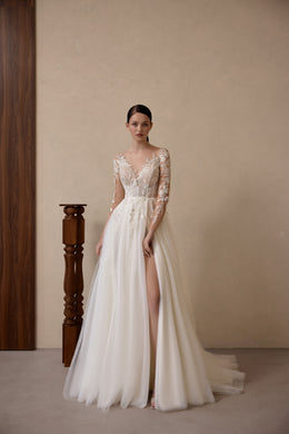 Ivory A-line wedding dress with an illusion V-neckline, long lace sleeves, thigh-high slit, and train