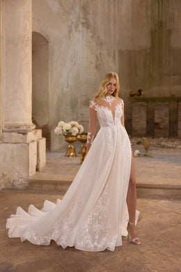 Full-length ivory wedding dress with a sheer V-neck bodice, floral lace details, glitter tulle, and a long train