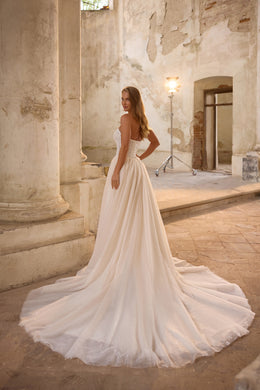 Ivory wedding dress with a strapless lace back, sparkling full skirt, and sweeping long train