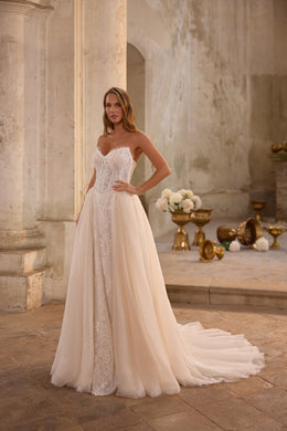 Ivory wedding dress with a sweetheart neckline, fitted lace bodice, glittering A-line skirt, and long train