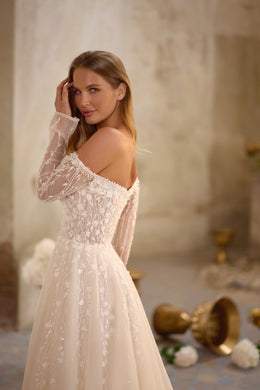 Ivory A-line wedding dress with an off-the-shoulder neckline, sheer lace sleeves, and a sparkling lace bodice