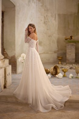 Ivory wedding dress shown from the back with sheer lace sleeves, an A-line skirt, and a long flowing train