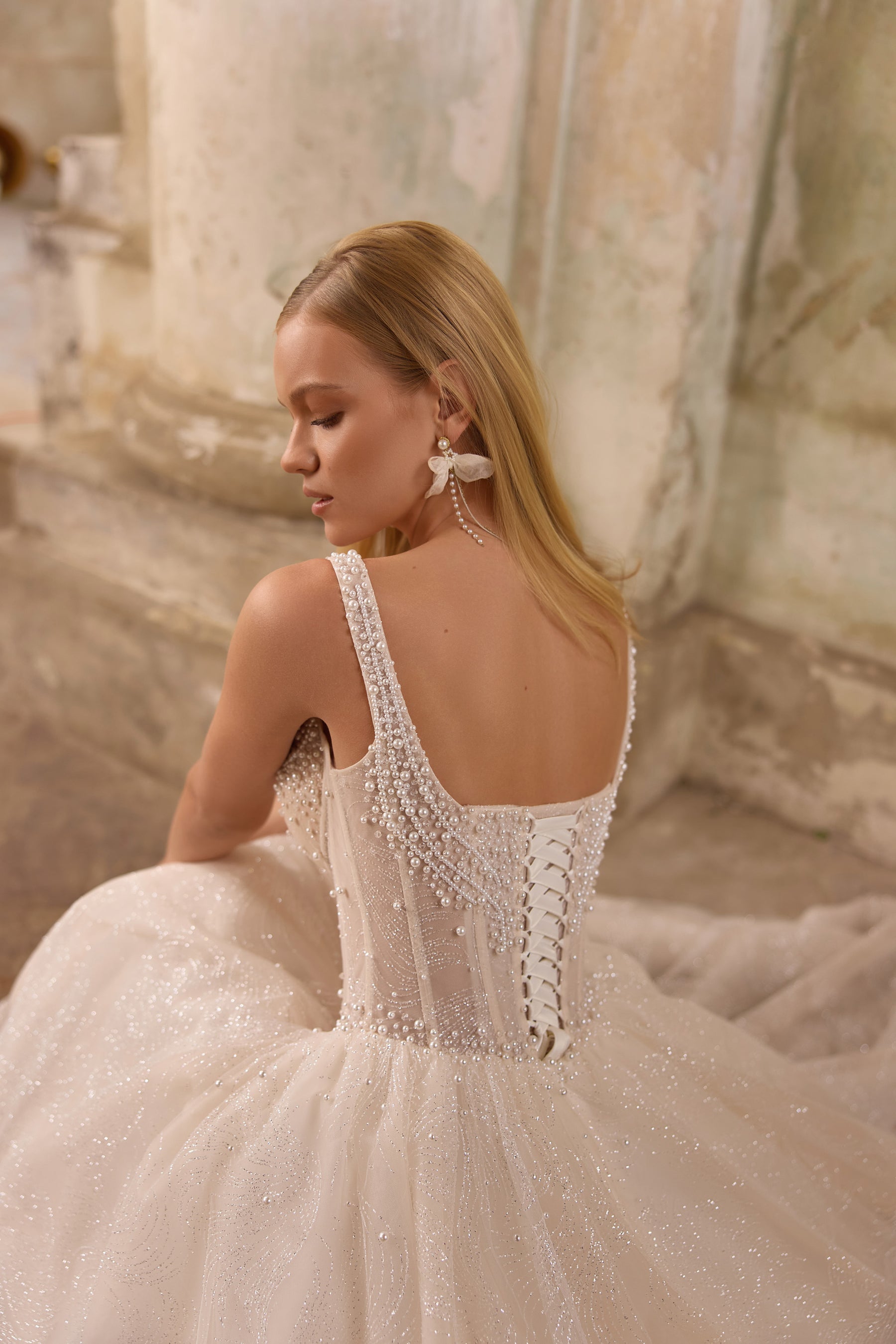 Beaded corset back with lace-up detailing and a glittering full skirt on an ivory wedding dress