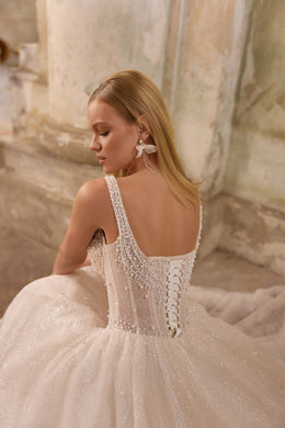 Beaded corset back with lace-up detailing and a glittering full skirt on an ivory wedding dress