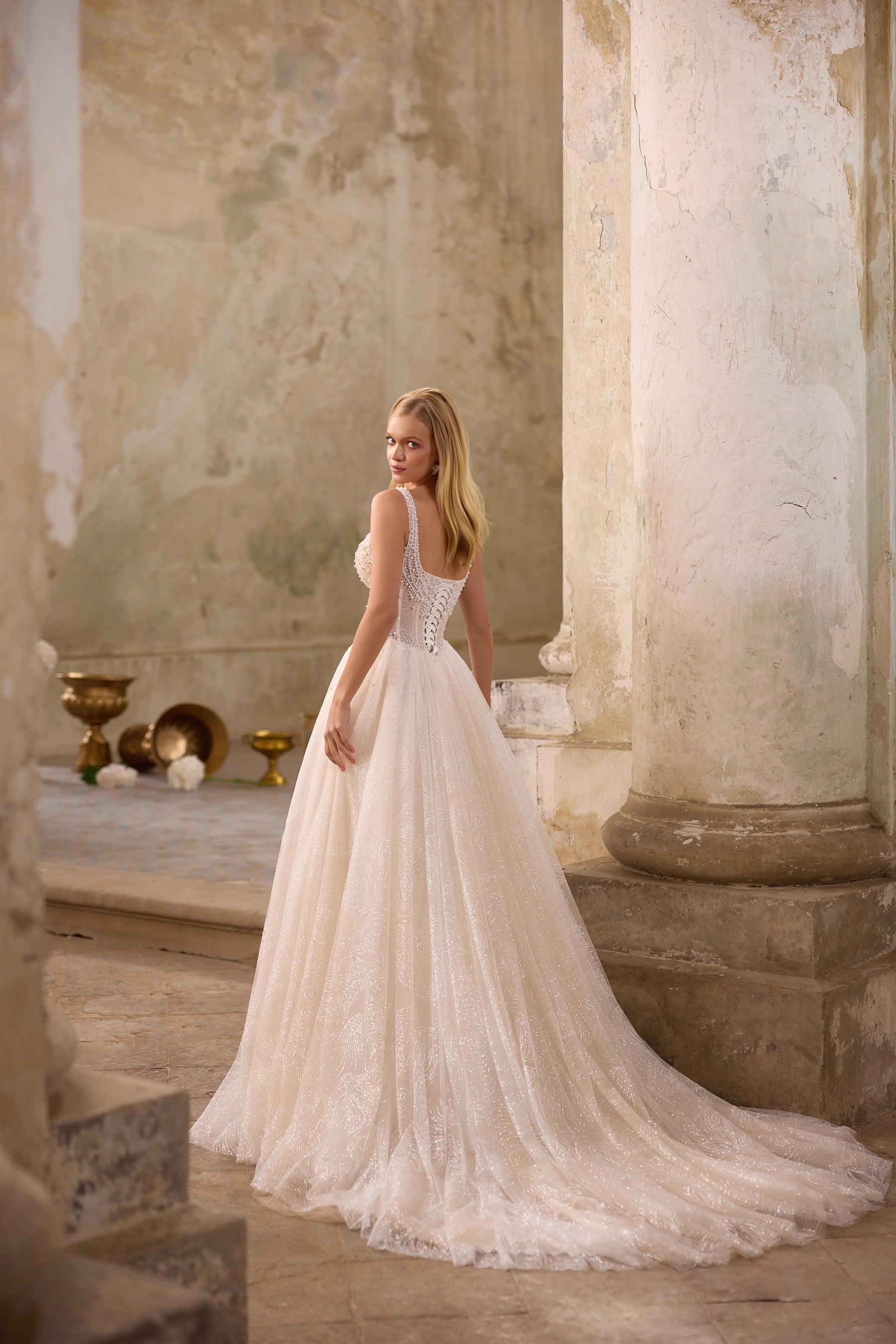 Lace-up back and sweeping train on a sparkling ivory A-line wedding dress