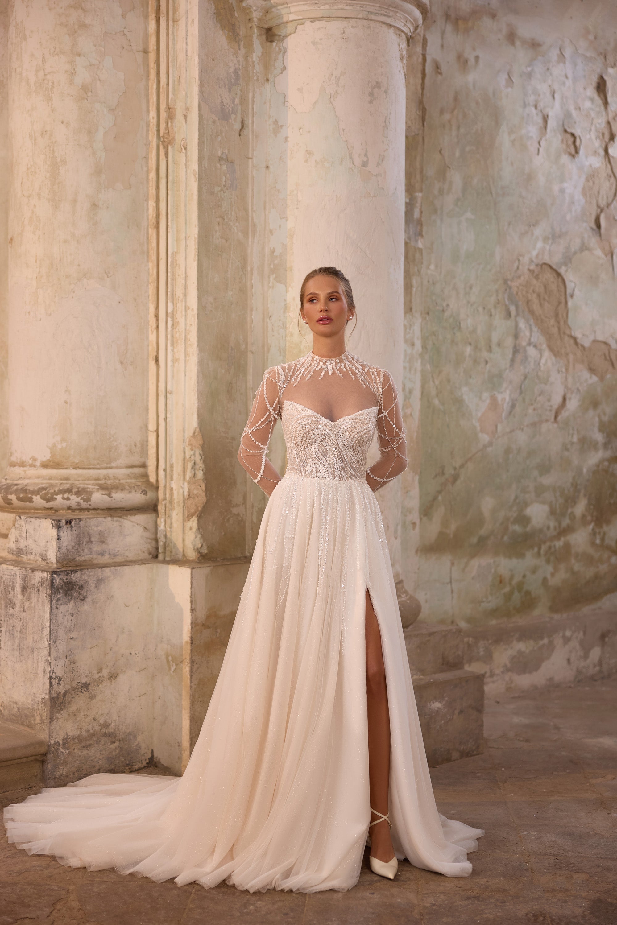 Ivory wedding dress with beaded illusion sleeves, sweetheart bodice, thigh slit, and sweeping train