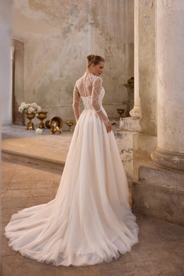 Back of an ivory wedding dress with beaded illusion sleeves, sheer back, and a long flowing train