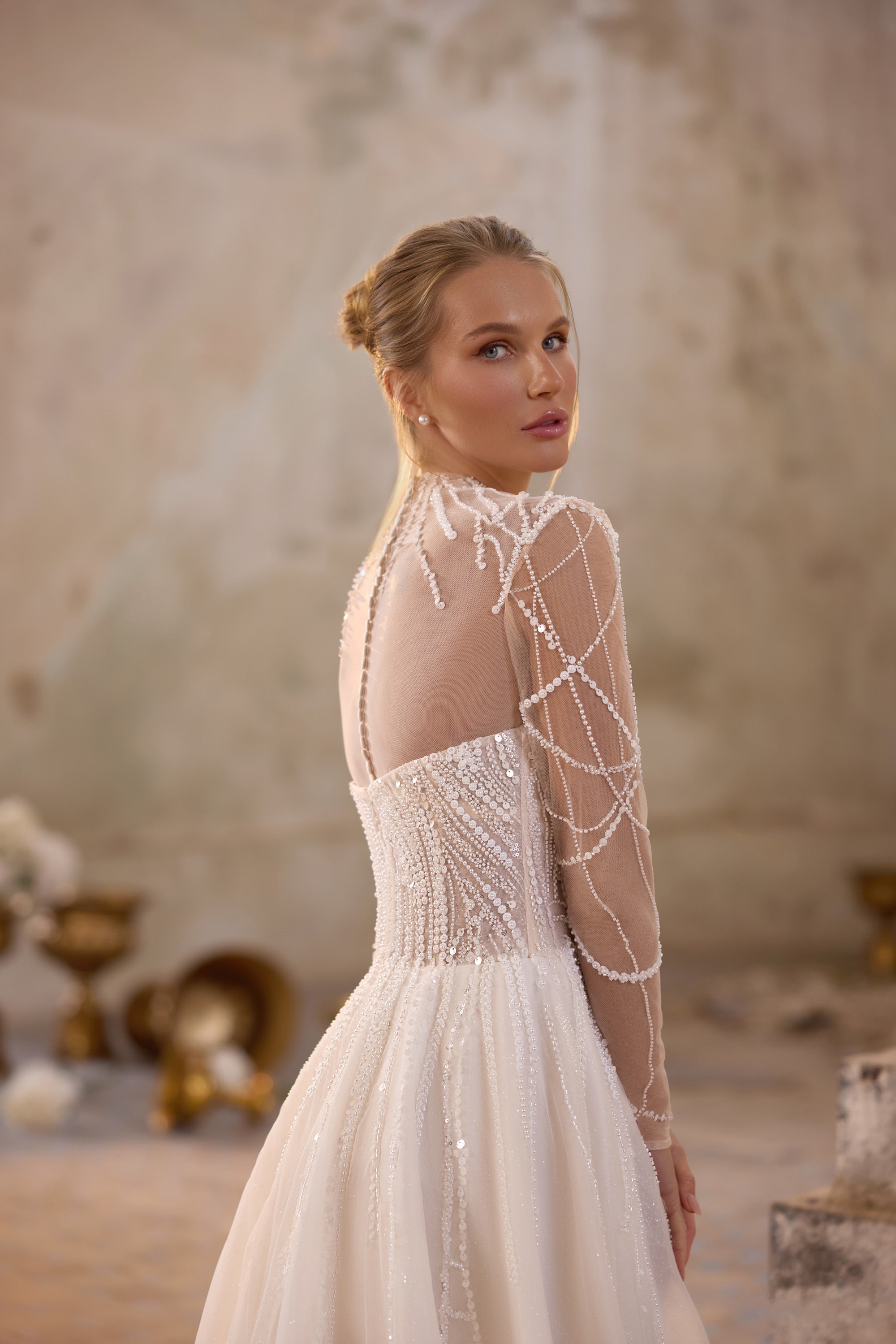 Sheer illusion back and beaded long sleeve detail on an ivory wedding dress