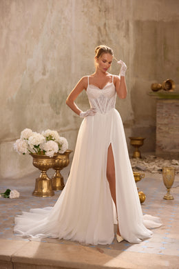 Ivory A-line wedding dress with a lace corset bodice, thin straps, high slit, and train