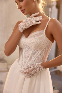 Close-up of intricate floral lace and beadwork on the bodice of an ivory wedding dress