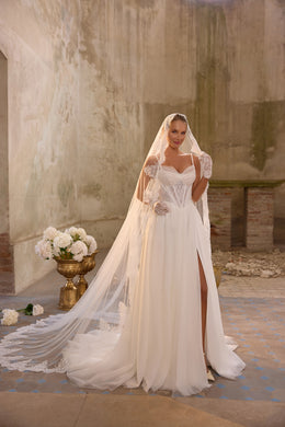 Ivory wedding dress with a lace-trimmed veil, fitted lace bodice, side slit, and sweeping train