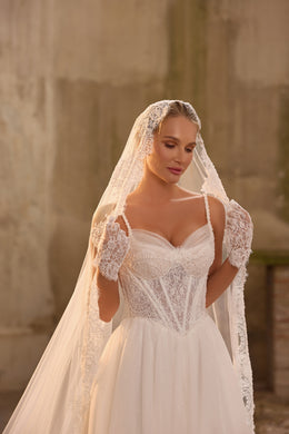 Delicate lace bodice with thin straps and a sweetheart neckline on an ivory wedding dress